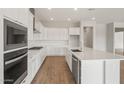 A modern kitchen featuring bright white cabinets, quartz countertops, and stainless steel appliances at 22660 E Pegasus Pkwy, Queen Creek, AZ 85142