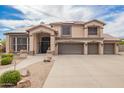 Charming two-story home with a three-car garage, covered entry, tile roof, and desert landscaping at 24916 N 80Th Ln, Peoria, AZ 85383