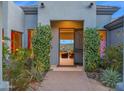 An inviting entryway adorned with blooming bushes, offering a glimpse into a stylishly furnished interior at 37221 N Holiday Ln, Carefree, AZ 85377
