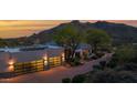 Stunning home exterior featuring a three car garage, elegant desert landscaping, and mountain views at 37221 N Holiday Ln, Carefree, AZ 85377