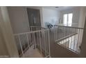 Upstairs hallway with white railing overlooking a lower room, leading to a bright room with a desk at 475 S Seawynds Blvd, Gilbert, AZ 85233