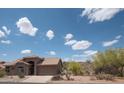 Beautiful single-story desert home with a tile roof, complemented by lush desert landscaping and a picturesque skyline at 4970 S Desert Willow Dr, Gold Canyon, AZ 85118