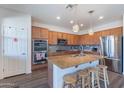 Modern kitchen features a center island with granite countertops, stainless appliances, and stylish lighting at 5239 W Leodra Ln, Laveen, AZ 85339