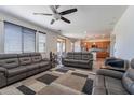 Open concept living room featuring hardwood floors, ceiling fan, large TV, and comfortable couches at 5239 W Leodra Ln, Laveen, AZ 85339
