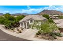 Charming two-story home boasts a desert landscape, tile roof, mountain views, and attached two car garage at 6026 E Sonoran Trl, Scottsdale, AZ 85266