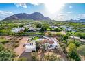 Aerial view of a luxury home featuring a sparkling pool, lush landscaping, and red tile roof with mountain backdrop at 6701 E San Miguel Ave, Paradise Valley, AZ 85253