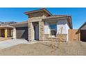 Inviting home exterior showcases stone detailing around the entrance, complementing the stucco and tile roof at 7718 W Minton St, Laveen, AZ 85339