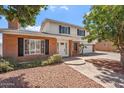 This house has lovely landscaping, a white and red brick exterior, and a driveway at 8545 E Heatherbrae Dr, Scottsdale, AZ 85251