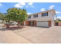 Home exterior featuring two-story design, driveway, lush tree, and well-kept landscaping at 8545 E Heatherbrae Dr, Scottsdale, AZ 85251