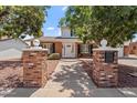 Inviting home exterior with brick columns, a walkway and mature shade trees at 8545 E Heatherbrae Dr, Scottsdale, AZ 85251