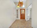 Bright foyer with a decorative glass front door, tile flooring, and high ceilings at 9127 E Siesta Ln, Scottsdale, AZ 85255