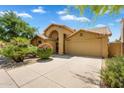 Inviting single-story home with well-maintained landscaping, an arched entryway, and attached two-car garage at 9127 E Siesta Ln, Scottsdale, AZ 85255