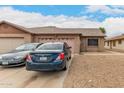 Cozy single-story brick home with a pink garage door, gravel front yard, and driveway parking at 9511 W Carol Ave, Peoria, AZ 85345