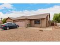 Charming single-story brick home with a two car garage and a desert-landscaped front yard at 9511 W Carol Ave, Peoria, AZ 85345