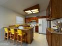 Functional kitchen featuring wood cabinets, breakfast bar, and essential appliances at 11022 S Iroquois Dr, Phoenix, AZ 85044