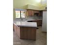 Functional kitchen boasts ample counter space, wooden cabinets, and a bright window view at 11052 N 10Th Pl, Phoenix, AZ 85020