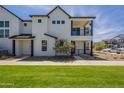 Inviting townhouse showcases a white exterior, black trim, a well-kept lawn, and a sunny blue sky at 11300 N Casa Dega Dr # 1081, Surprise, AZ 85388