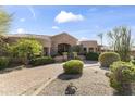 Expansive front view of this stunning residence displaying manicured landscaping and circular driveway at 13249 E Summit Dr, Scottsdale, AZ 85259