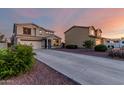 A suburban two-story home with a long driveway and well-maintained landscaping under a twilight sky at 1647 W Gold Mine Way, San Tan Valley, AZ 85144