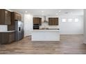 Bright and airy kitchen boasts a large central island, stainless appliances, and stylish wood floors at 18522 W Mohave St, Goodyear, AZ 85338
