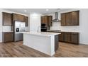 Modern kitchen features an island with white counter tops and wooden floors at 18522 W Mohave St, Goodyear, AZ 85338