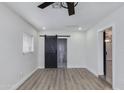 Minimal bedroom featuring light gray flooring, bright white walls, and sliding barn door to bathroom at 2501 E Campbell Ave, Phoenix, AZ 85016