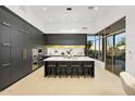 Modern kitchen with sleek black cabinets, a large island, stainless steel appliances, and views of the outdoors at 28754 N 107Th St, Scottsdale, AZ 85262