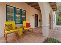 Inviting covered porch with colorful chairs, terracotta tiles, and architectural details at 307 E Catalina Dr, Phoenix, AZ 85012