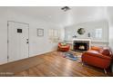 Bright living room featuring a cozy fireplace, hardwood floors, and stylish decor at 307 E Catalina Dr, Phoenix, AZ 85012