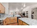 Open kitchen with wood floors, granite countertops, cabinets, stainless steel appliances, and adjacent living area at 4043 S Shady Ct, Gilbert, AZ 85297