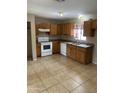 Bright kitchen with wood cabinets, white appliances, and tile flooring, ready for your personal touch at 4119 N 105Th Ln, Phoenix, AZ 85037