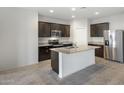 Well-equipped kitchen with a granite island, stainless steel appliances, and dark wood cabinetry at 42895 W Vincent Dr, Maricopa, AZ 85138