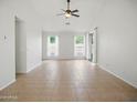 Bright living room with neutral tile flooring, ceiling fan, and natural light from the windows at 44010 W Wade Dr, Maricopa, AZ 85138