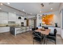 Modern kitchen features white cabinets, stainless steel appliances, an island with seating, and an adjacent dining area at 4416 N 37Th Way, Phoenix, AZ 85018