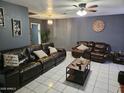 Comfortable living room with leather sofas, neutral decor, and tile flooring, perfect for relaxing and entertaining at 4507 E Saint Catherine Ave, Phoenix, AZ 85042