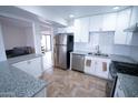 Modern kitchen features stainless steel appliances, granite countertops, white cabinetry, and a subway tile backsplash at 5217 N 18Th Dr, Phoenix, AZ 85015