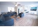 Open-concept living room boasts a modern ceiling fan, sleek furniture, and light wood flooring for a bright aesthetic at 5217 N 18Th Dr, Phoenix, AZ 85015