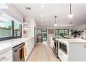 Bright, open kitchen with modern appliances, white cabinetry, and large windows for natural light at 5238 E Beck Ln, Scottsdale, AZ 85254