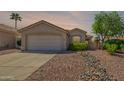Charming single-story home with a well-maintained yard, desert landscaping, and a two-car garage at 6027 E Sayan Cir, Mesa, AZ 85215
