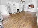 Open living area with hardwood floors, built-in shelving, and an archway leading to the kitchen at 6617 W Cavedale Dr, Phoenix, AZ 85083