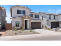 Charming two-story home featuring a stone entrance, dark shutters, and a spacious two-car garage at 7420 S 76Th Ln, Laveen, AZ 85339