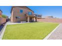 Expansive backyard featuring lush green grass, a covered patio, and a paved area with a fire pit at 900 E Harrison St, Chandler, AZ 85225