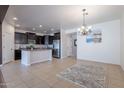 Open-concept kitchen featuring dark cabinets, stainless steel appliances, and tile flooring throughout the space at 900 E Harrison St, Chandler, AZ 85225