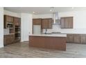 Spacious kitchen boasts wood cabinets, an island, stainless steel appliances, and tiled backsplash at 9775 S 36Th Ln, Laveen, AZ 85339