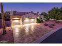 Attractive single-story home featuring an expansive driveway, three-car garage, and desert landscaping at 12928 W Santa Ynez Dr, Sun City West, AZ 85375