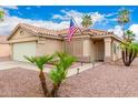 Beautiful one-story home with mature landscaping and a charming front entryway, featuring a US flag at 13359 W Post Dr, Surprise, AZ 85374