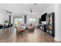 Spacious living room with hardwood floors, stylish furniture, and ample natural light from sliding glass doors at 14549 W Corrine Dr, Surprise, AZ 85379