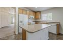 Well-lit kitchen featuring tile floors, center island, white appliances, and wood cabinets at 1726 E Primera Dr, Casa Grande, AZ 85122