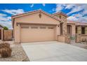 Single story home featuring a two car garage, stone accents, and low maintenance desert landscaping at 17907 W Cedarwood Ln, Goodyear, AZ 85338