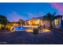 Inviting backyard with a sparkling pool, lounge chairs, and ambient lighting for entertaining at 19414 W Pasadena Ave, Litchfield Park, AZ 85340